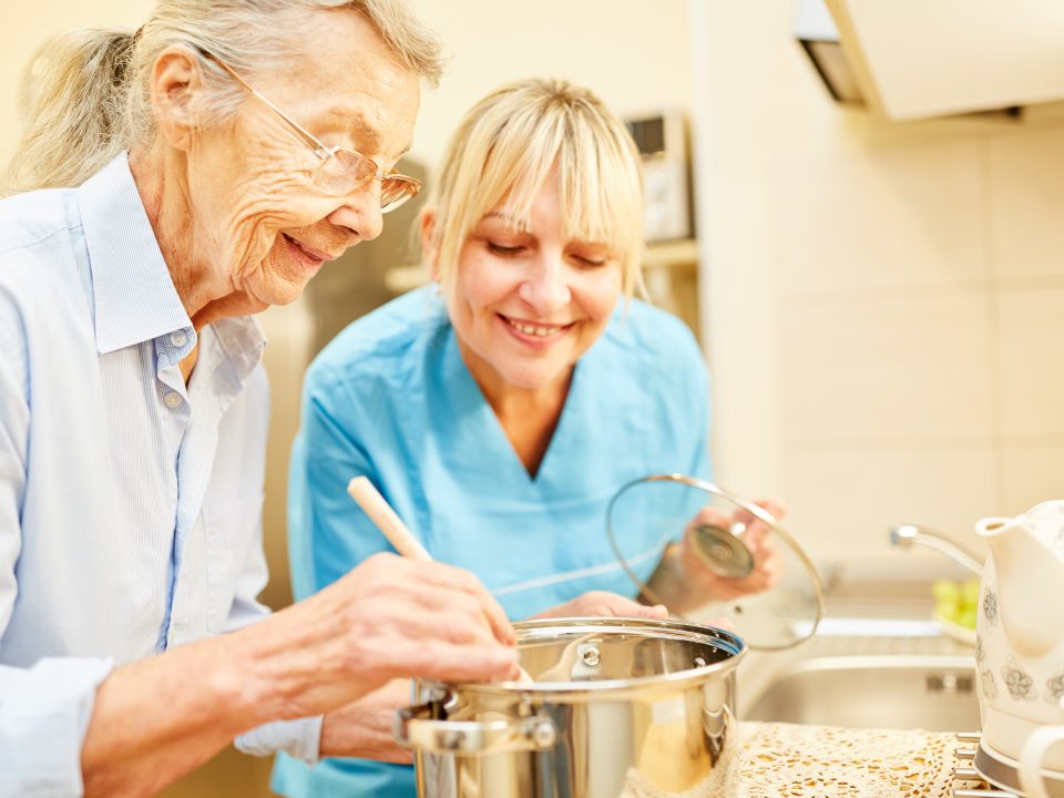elderly cooking with caregiver assistance